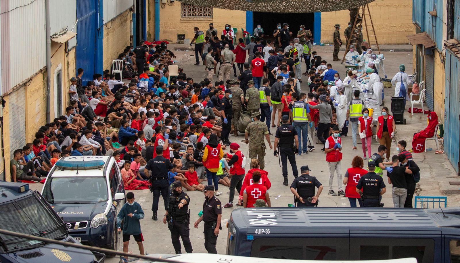 epa09213424 Dozens of underage migrants wait for a COVID-19 test after their arrival in Ceuta, Spain, 19 May 2021. Spain's Government considers that the massive arrival of some 8,000 irregular migrants to Ceuta from Morocco since 18 May is an assault on the border caused by the lack of control of the border by Morocco's Government and not a migratory crisis.  EPA/BRAIS LORENZO