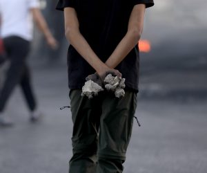 epa09213389 Palestinian protester holds stones during clashes with Israeli troops at Huwwara checkpoint near the West Bank City of Nablus, 19 May 2021. Clashes erupted 06 May over the forced eviction of six Palestinian families from their homes in Sheikh Jarrah neighborhood in favor of Jewish families who claimed they used to live in the houses before fleeing in the 1948 war that led to the creation of Israel. In response to days of violent confrontations between Israeli security forces and Palestinians in Jerusalem, various Palestinian militants factions in Gaza launched rocket attacks since 10 May that killed at least 12 Israelis to date. The Palestinian health ministry said that at least 219 Palestinians, including 63 children, were killed in the retaliatory Israeli airstrikes.  EPA/ALAA BADARNEH