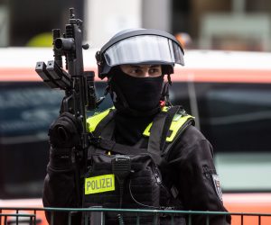 epa09228640 A police officer secures the front of a Deutche bank branch at the Johannisthaler Chaussee in Berlin, Germany, 26 May 2021. According to the police, two men were injured, including the alleged perpetrator, during a bank robbery in Berlin's Neukoelln distcrit.  EPA/FILIP SINGER