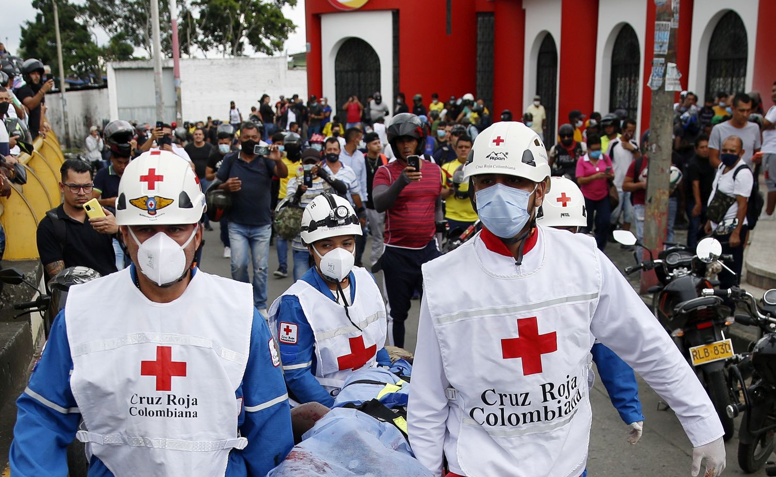 epa09234351 ATTENTION EDITORS: GRAPHIC CONTENT Members of the Colombian Red Cross lift the lifeless body of a man, during the demonstrations amid the National Strike, in the La Luna sector, in Cali, Colombia, 28 May 2021. Three people died on 28 May in confusing events that occurred in Cali, the epicenter of the protests in Colombia and the main city in the southwest of the country, during the fifth day of the 'national strike', confirmed the mayor of the city, Jorge Ivan Ospina. The crimes were committed in the La Luna sector, in the center of the city and one of the places where the scenes of greatest violence have been experienced since the protests began a month ago.  EPA/Ernesto Guzman Jr ATTENTION EDITORS: GRAPHIC CONTENT