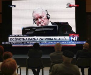epa09255515 People watch the transmission of the International Criminal Tribunal for Former Yugoslavia court appeals verdict session for war-time Bosnian Serb, General Ratko Mladic during his trial in The Hague, broadcasted on TV in Sarajevo, Bosnia, 08 June 2021. Ratko Mladic, was sentenced to life imprisonment by the ICY on 08 June, after the judges found him guilty of the 1995 Srebrenica Genocide in which 8,000 Muslim men and boys were killed and other war crimes charges.  EPA/FEHIM DEMIR