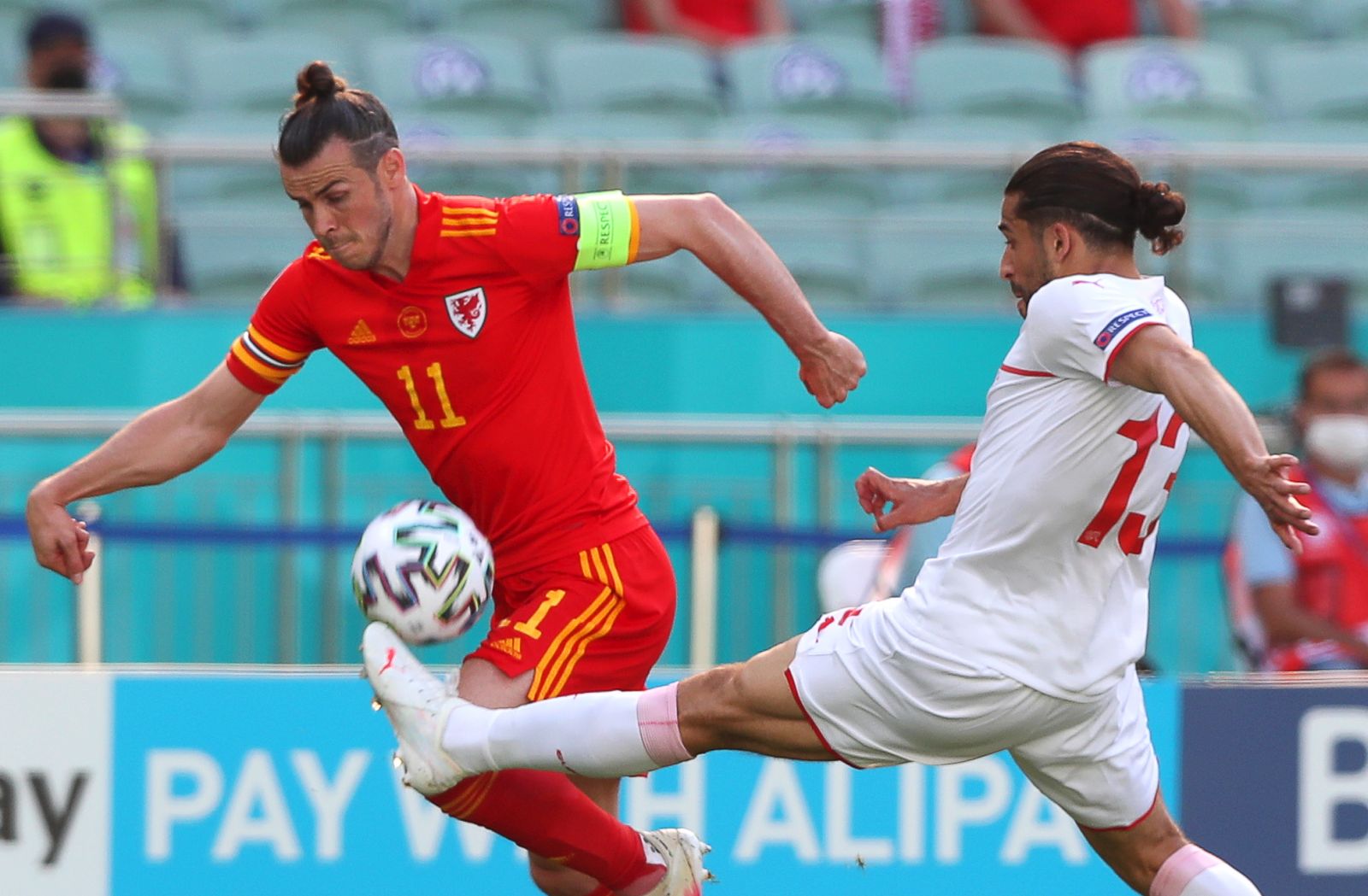 epa09264326 Gareth Bale (L) of Wales in action against Ricardo Rodriguez (R) of Switzerland during the UEFA EURO 2020 group A preliminary round soccer match between Wales and Switzerland in Baku, Azerbaijan, 12 June 2021.  EPA/Tolga Bozoglu / POOL (RESTRICTIONS: For editorial news reporting purposes only. Images must appear as still images and must not emulate match action video footage. Photographs published in online publications shall have an interval of at least 20 seconds between the posting.)