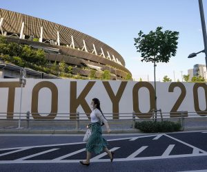 epa09279196 A pedestrian walks past the New National Stadium, or the Olympic Stadium for the Opening Ceremony, Closing Ceremony and Athletics event, in Tokyo, Japan, 17 June 2021, after the Japanese government decided to lift the COVID-19 state of emergency as scheduled to end on 20 June 2021, in nine prefectures including Tokyo. The government also decided to keep restrictions to avoid a rebound of infections before the Tokyo Olympic Games.  EPA/KIMIMASA MAYAMA