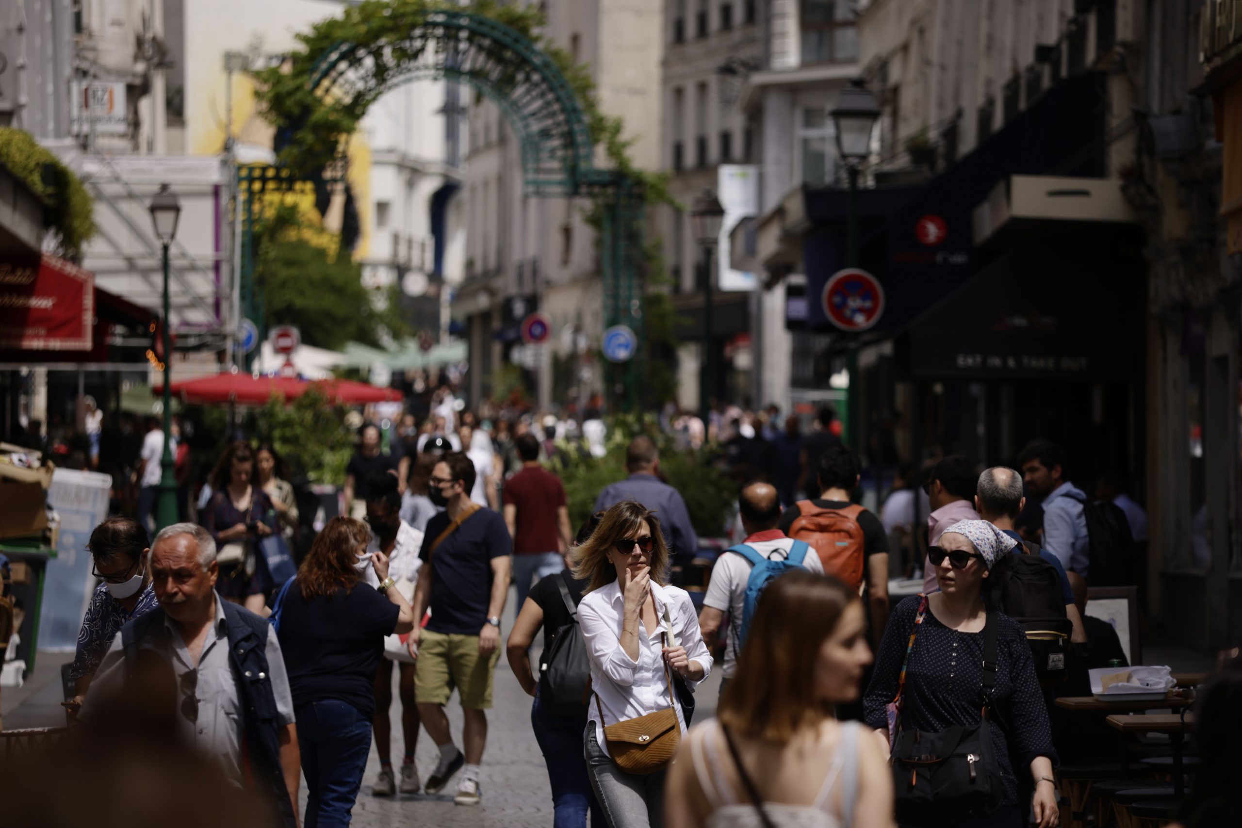 epa09279459 People without protective face mask walk along Montorgueil street in Paris, France, 17 June 2021. France eases some of its COVID-19 restrictions starting on 17 June, allowing not wearing a face mask in the streets.  EPA/YOAN VALAT