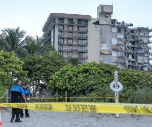 epa09298424 Miami Dade police officers guard the entrance to the partial collapsed 12-story condominium building in Surfside, Florida, USA, 24 June 2021. Miami-Dade Fire Rescue officials said more than 80 units responded to the collapse at the condominium building near 88th Street and Collins Avenue just north of Miami Beach around 2 a.m.  EPA/CRISTOBAL HERRERA-ULASHKEVICH