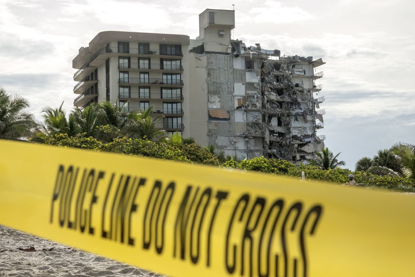 epaselect epa09299838 View of a 12-story condominium building that partially collapsed in Surfside, Florida, USA, 24 June 2021. Miami-Dade Fire Rescue officials said more than 80 units responded to the collapse at the condominium building near 88th Street and Collins Avenue just north of Miami Beach around 2 a.m. There are currently 99 people unaccounted for.  EPA/CRISTOBAL HERRERA-ULASHKEVICH