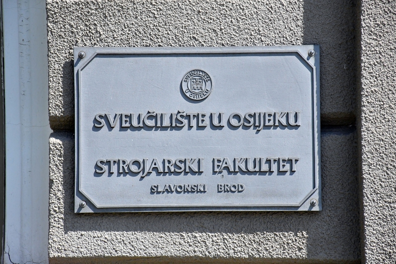 11.08.2020., Slavonski Brod - Zakonom o osnivanju Sveucilista u Slavonskom Brodu i danom upisa u sudski registar, 3. kolovoza 2020. godine, kada je Sveuciliste pocelo obavljati djelatnost Strojarski fakultet u Slavonskom Brodu postao je sastavni dio Sveucilista. Ipak, dok se ne izradi nova, jos uvijek na zgradi fakulteta stoji stara oznaka Sveucilista u Osijeku.
Photo: Ivica Galovic/PIXSELL