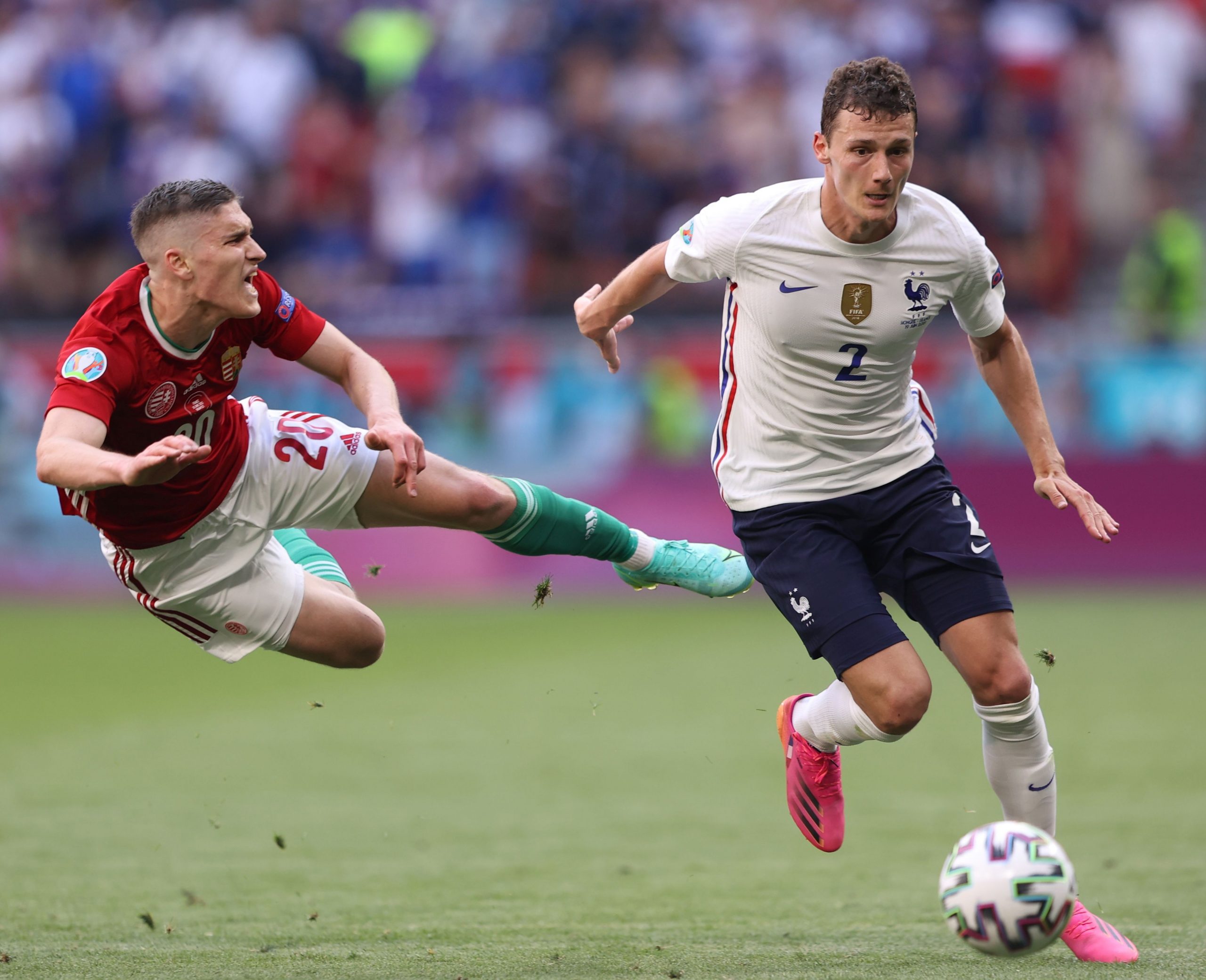 epa09285642 Roland Sallai (L) of Hungary in action against Benjamin Pavard of France during the UEFA EURO 2020 group F preliminary round soccer match between Hungary and France in Budapest, Hungary, 19 June 2021.  EPA/Alex Pantling / POOL (RESTRICTIONS: For editorial news reporting purposes only. Images must appear as still images and must not emulate match action video footage. Photographs published in online publications shall have an interval of at least 20 seconds between the posting.)