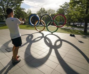 epaselect epa09279192 A visitor takes a photo of the Olympic Rings monument near the New National Stadium, or the Olympic Stadium for the Opening Ceremony, Closing Ceremony and Althetics event, in Tokyo, Japan, 17 June 2021, after the Japanese government decided to lift the COVID-19 state of emergency as scheduled to end on 20 June 2021, in nine prefectures including Tokyo. The government also decided to keep restrictions to avoid a rebound of infections before the Tokyo Olympic Games.  EPA/KIMIMASA MAYAMA