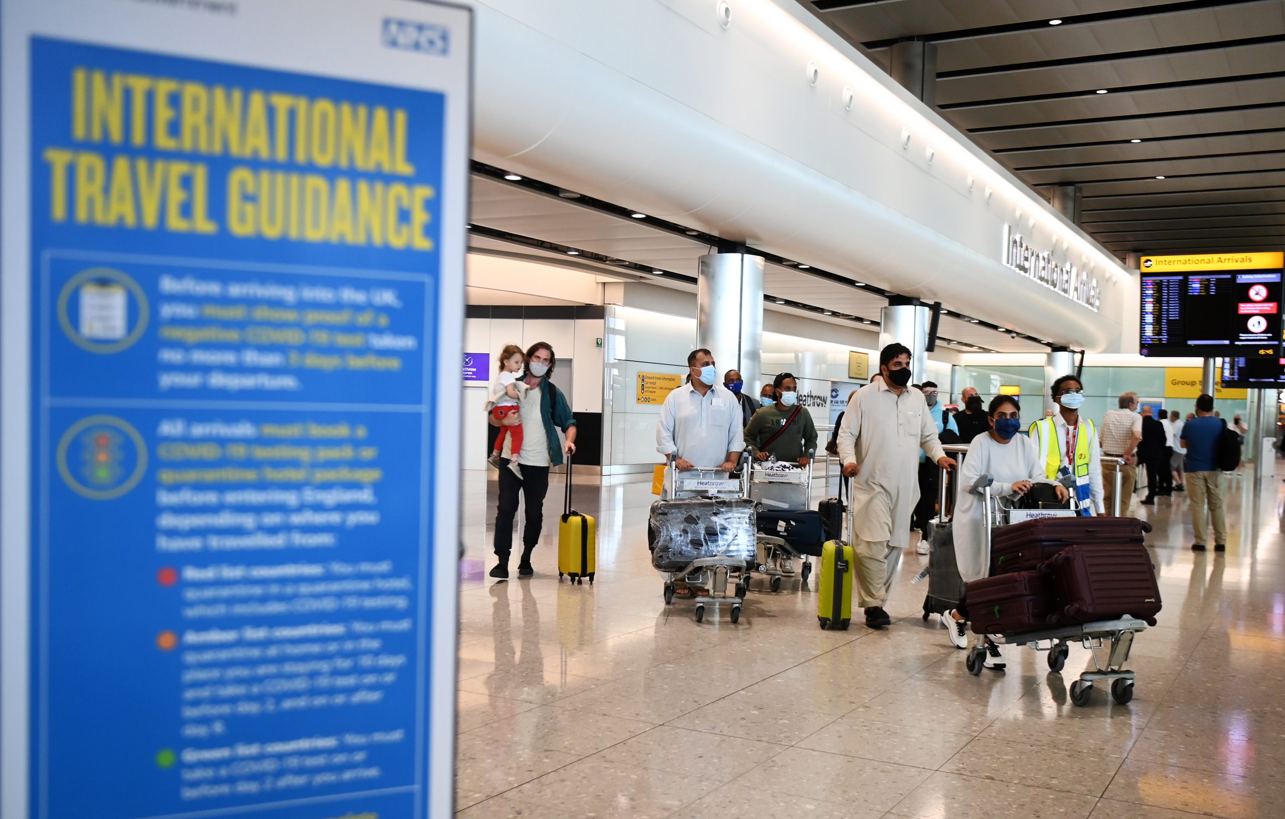 epa09255359 Travellers arrive at the Heathrow airport in London, Britain, 08 June 2021. Extra flights to the UK have been departing Portugal as holidaymakers scrambled to leave on the last day before the country moved to the amber travel list. Many travellers missed the deadline and will have to quarantine for up to ten days on return.  EPA/ANDY RAIN