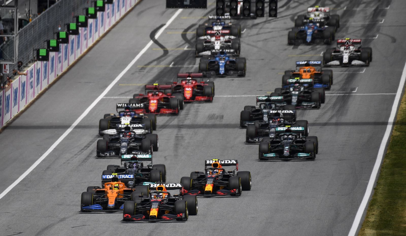 epa09322160 British Formula One driver Lando Norris (bottom-L) of McLaren, Dutch Formula One driver Max Verstappen (bottom-C) and teammate Mexican Formula One driver Sergio Perez (bottom-R) of Red Bull Racing in action during the Formula One Grand Prix of Austria at the Red Bull Ring in Spielberg, Austria, 04 July 2021.  EPA/CHRISTIAN BRUNA