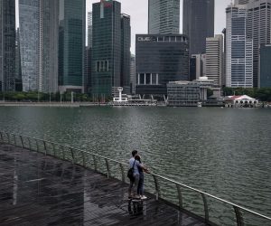 epa09325551 A couple embraces in front of the financial district across the Marina Bay in Singapore, 06 July 2021. Economists have reported a better than expected growth of 1.3 percent in the Singapore economy for the first quarter of 2021, according to the Monetary Authority of Singapore.  EPA/WALLACE WOON