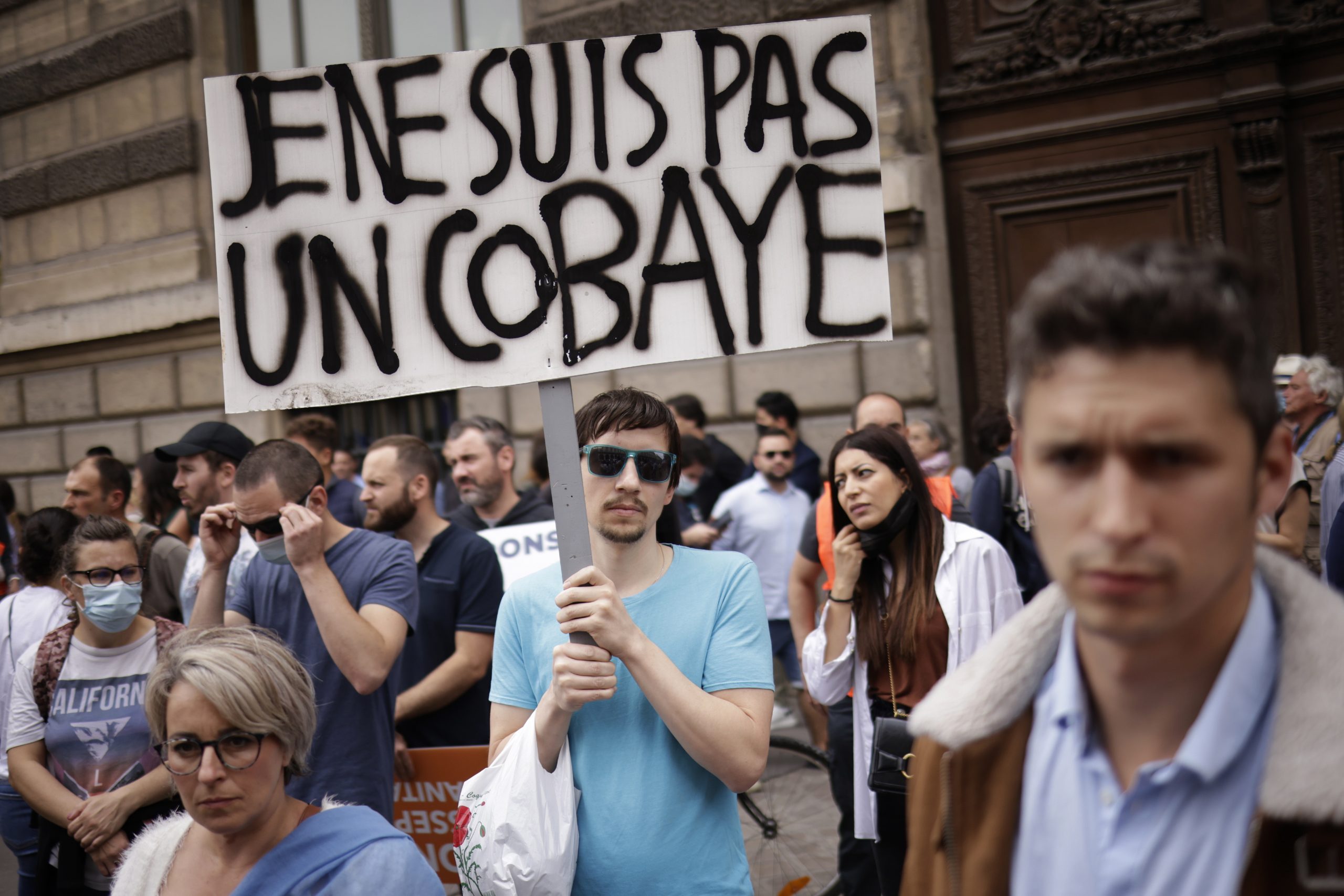 epa09350326 Thousands of protesters gather by the Louvre pyramid during a demonstration against the COVID-19 vaccination in Paris, and the banner reads ‘I am not a guinea pig’, France, 17 July 2021. In a recent TV statement, French President Emmanuel Macron announced France will extend the use of its Vaccinal Passeport to cultural place, transport, restaurant, etc, after Covid-19 infections soared this week because of the more infectious Delta variant.  EPA/YOAN VALAT