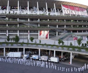 epa09351550 Staff members gather around the National Stadium, the main venue of the Tokyo 2020 Olympics and Paralympics, ahead of the opening ceremony of the Tokyo 2020 Games in Tokyo, Japan, 18 July 2021. Just five days before the opening of the Tokyo Games, latest polls show that a major part of the population is concerned about the the Olympics as Tokyo recorded 1,000 new COVID-19 cases for the fifth straight day.  EPA/FRANCK ROBICHON