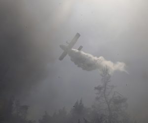 epa09370847 A firefighting aircraft douses a wildfire in the area of Stamata, in north-eastern Athens, Greece, 27 July 2021. Firefighting forces are operating in the area of Stamata, in the Attica region, to contain a wildfire that broke out earlier in the day. Some 22 fire engines with 68 crew members, three teams of firemen on foot, the municipality's water trucks along with four firefighting aircraft, and five water dropping helicopters are currently battling the blaze which is very close to inhabited areas. In the meanwhile, the Civil Protection's emergency number 112 was activated in the wider region of Stamata and Rodopoli informing the citizens to be on alert and follow authorities' instructions.  EPA/YANNIS KOLESIDIS