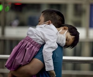 epa09376434 A man caring a child walks at the railway station in Shanghai, China, 29 July 2021. China reported 24 new locally transmitted COVID-19 cases, according to the National Health Commission. More than 170 people have been diagnosed with the Delta variant. The main outbreak is in the eastern city of Nanjing, in Jiangsu province.  EPA/ALEX PLAVEVSKI