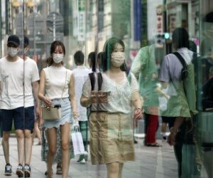 epa09376457 Passersby wearing face masks are reflected in a display window at Ginza shopping district in Tokyo, Japan, 29 July 2021. Japan's total COVID-19 new cases crossed the 10,000 mark for the first time as Tokyo records a surge of infections.  EPA/FRANCK ROBICHON