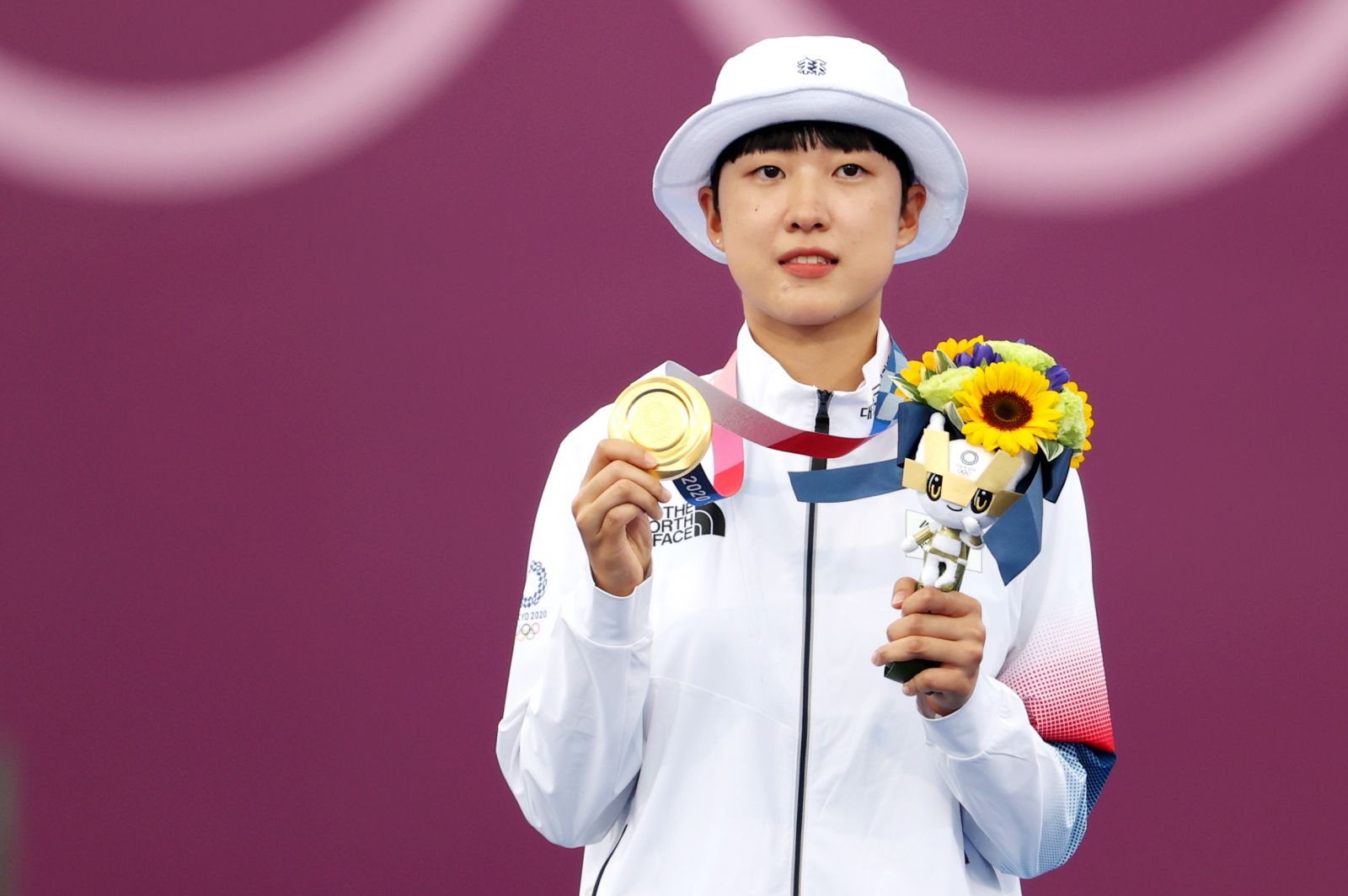 epa09379026 South Korean archer An San poses for a photo while showing off her gold medal on the podium during the award ceremony of the women's individual event during the Archery events of the Tokyo 2020 Olympic Games at the Yumenoshima Park in Tokyo, Japan, 30 July 2021.  EPA/YONHAP SOUTH KOREA OUT