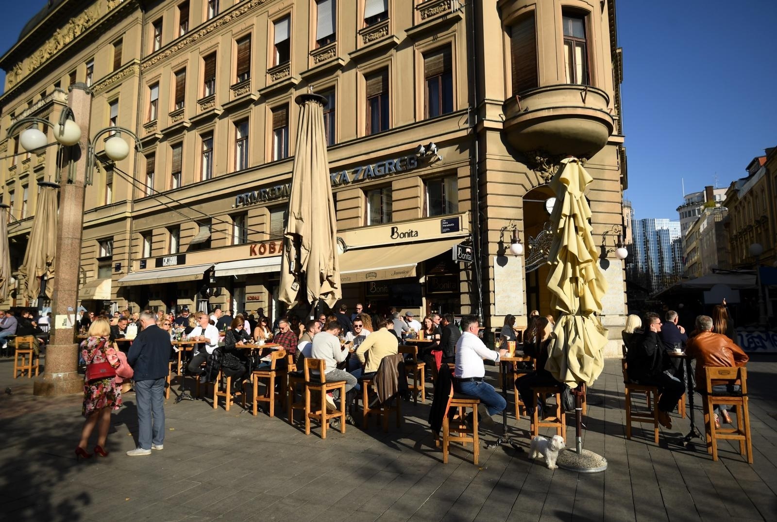 31.10.2020., Zagreb - Lijepo vrijeme izmamilo je ljude u kafice na Cvjetnom trgu, ceka se u redu kako bih se sjelo pod suncem. Ljudi uzivaju u kavicama, pivicama, guzve su velike iako stozer zbog situacije s koronom zabranjuje veca okupljanja i kafici imaju dozvole radit. Konobari imaju maske i poneki gost ima masku al kakva je guzva konobar ne stinge ni stol obrisat. Photo: Marko Lukunic/PIXSELL