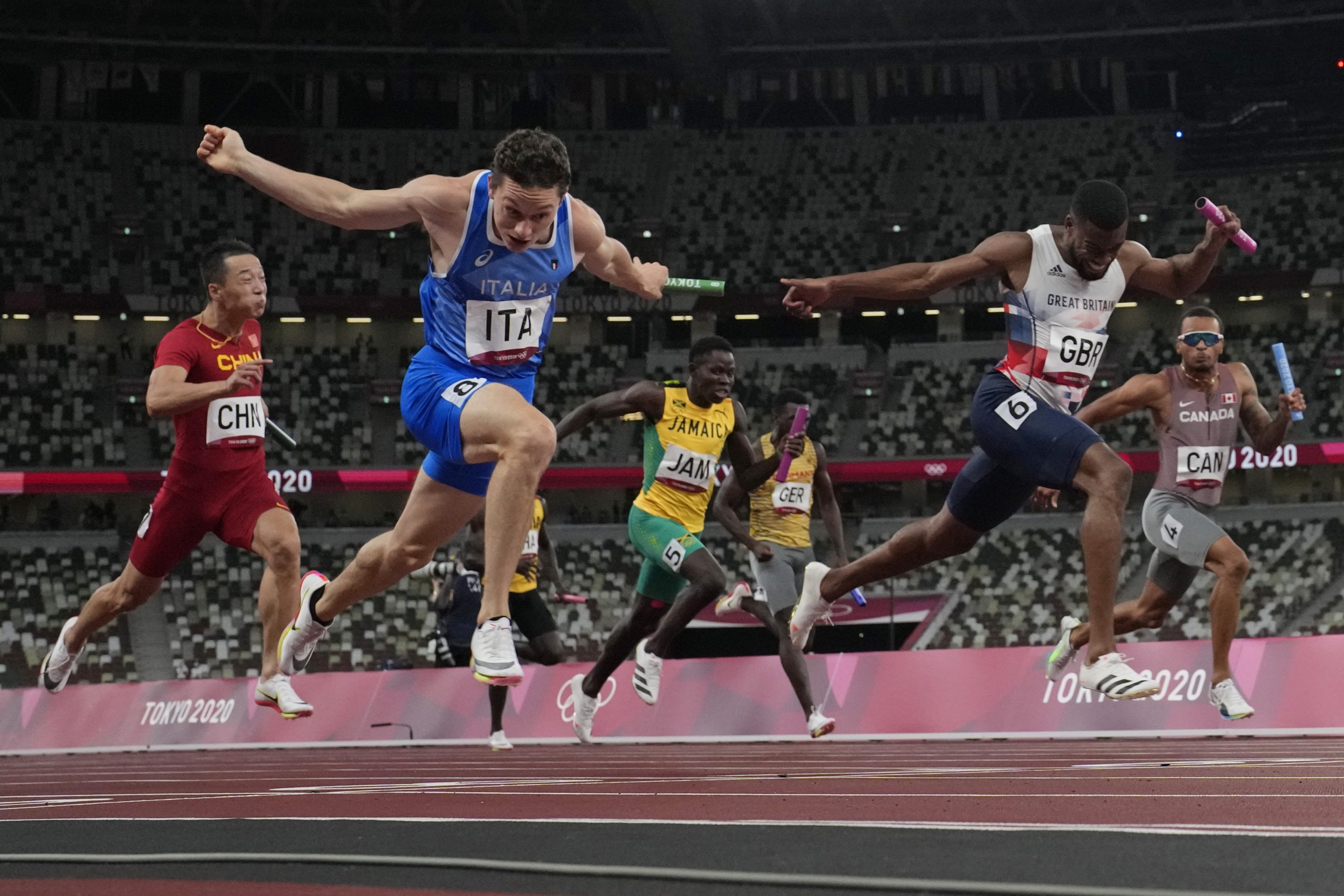 Filippo Tortu, of Italy, crosses the finish line ahead of Nethaneel Mitchell-Blake, of Britain, to lead his to team a gold medal in the men's 4x100-meter relay at the 2020 Summer Olympics, Friday, Aug. 6, 2021, in Tokyo. (AP Photo/David J. Phillip)