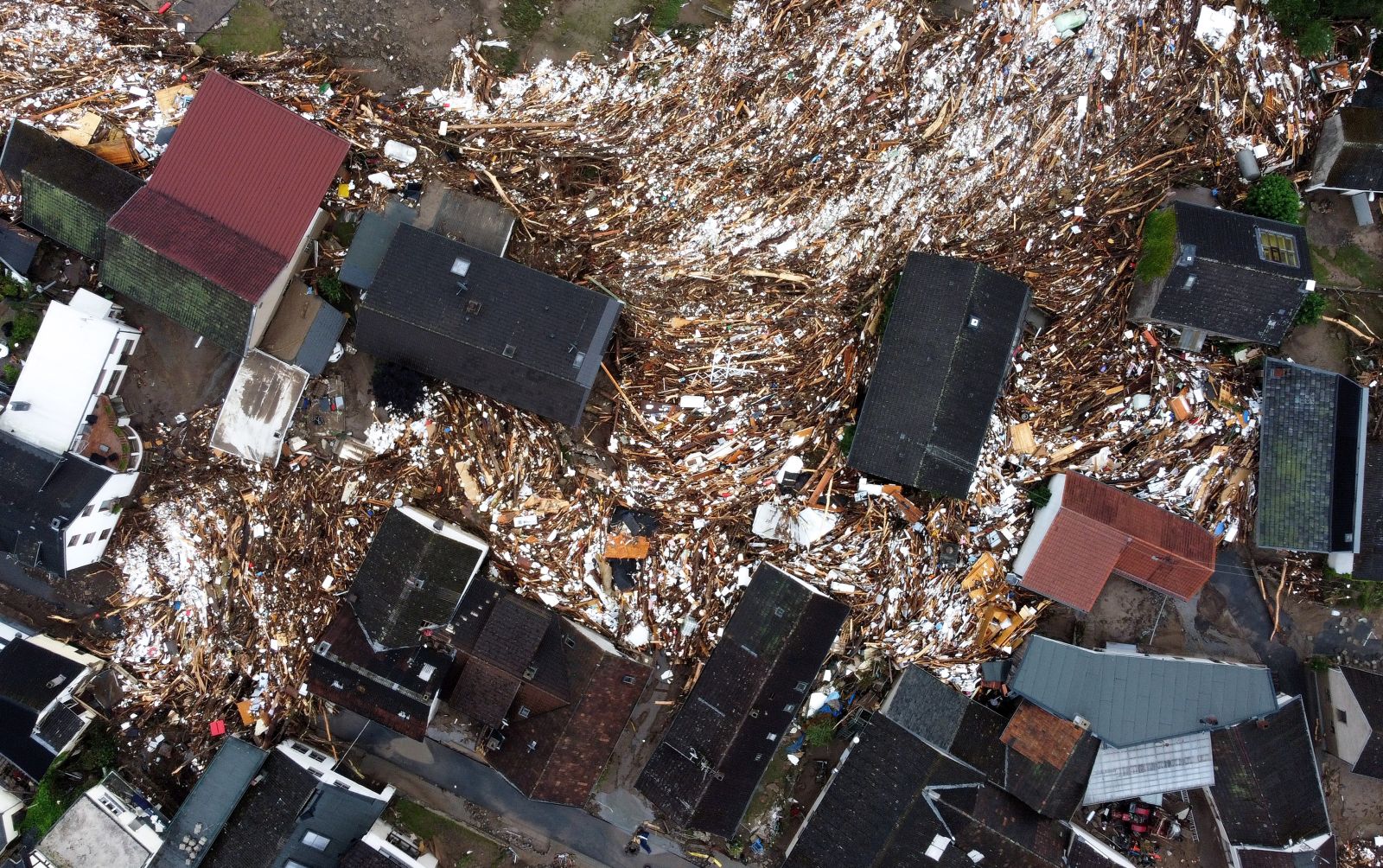epa09347810 An aerial picture taken with a drone shows the destroyed village of Schuld in the district of Ahrweiler after heavy flooding of the river Ahr, in Schuld, Germany, early 16 July 2021. Large parts of Western Germany were hit by heavy, continuous rain in the night to 15 July, resulting in local flash floods that destroyed buildings and swept away cars. The number of deaths after storms in Rhineland-Palatinate and North Rhine-Westphalia increased to at least 81 in the course of late 15 July. The Bad Neuenahr, Ahrweiler and Euskirchen areas were particularly hard hit, according to the police. Some of the dead have not yet been recovered, and people are still missing.  EPA/SASCHA STEINBACH