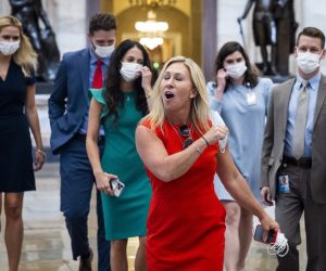 epa09380539 Republican Representative from Georgia Marjorie Taylor Greene removes her mask dramatically while crossing from the House side of the US Capitol (where masks are required) to the Senate side (where they are not) in Washington, DC, USA, 30 July 2021. On 27 July, Brian Monahan, the Capitol's attending physician, reimposed a mask mandate for House lawmakers and congressional staff.  EPA/JIM LO SCALZO