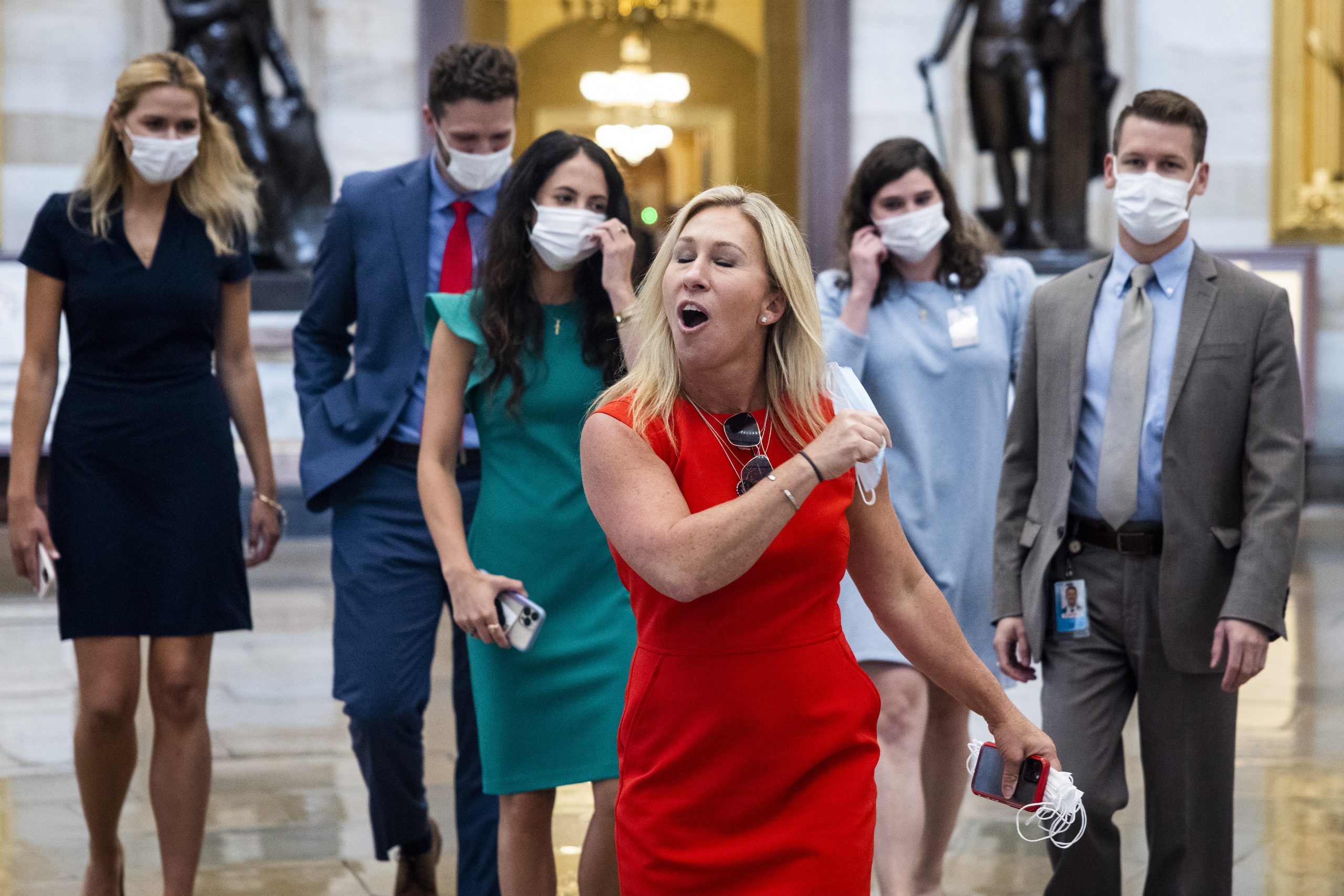 epa09380539 Republican Representative from Georgia Marjorie Taylor Greene removes her mask dramatically while crossing from the House side of the US Capitol (where masks are required) to the Senate side (where they are not) in Washington, DC, USA, 30 July 2021. On 27 July, Brian Monahan, the Capitol's attending physician, reimposed a mask mandate for House lawmakers and congressional staff.  EPA/JIM LO SCALZO
