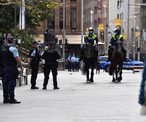 epa09380842 New South Wales police patrol George St in front of the Sydney Town Hall in anticipation of an anti-lockdown rally in Sydney, New South Wales, Australia, 31 July 2021.  EPA/MICK TSIKAS AUSTRALIA AND NEW ZEALAND OUT
