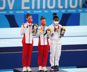 epa09390683 Gold medalist Chenchen Guan (C) of China, silver medalist Xijing Tang (L) of China, and bronze medalist Simone Biles (R) of the USA pose during the victory ceremony of the Women's Balance Beam Final during the Artistic Gymnastics events of the Tokyo 2020 Olympic Games at the Ariake Gymnastics Centre in Tokyo, Japan, 03 August 2021.  EPA/TATYANA ZENKOVICH