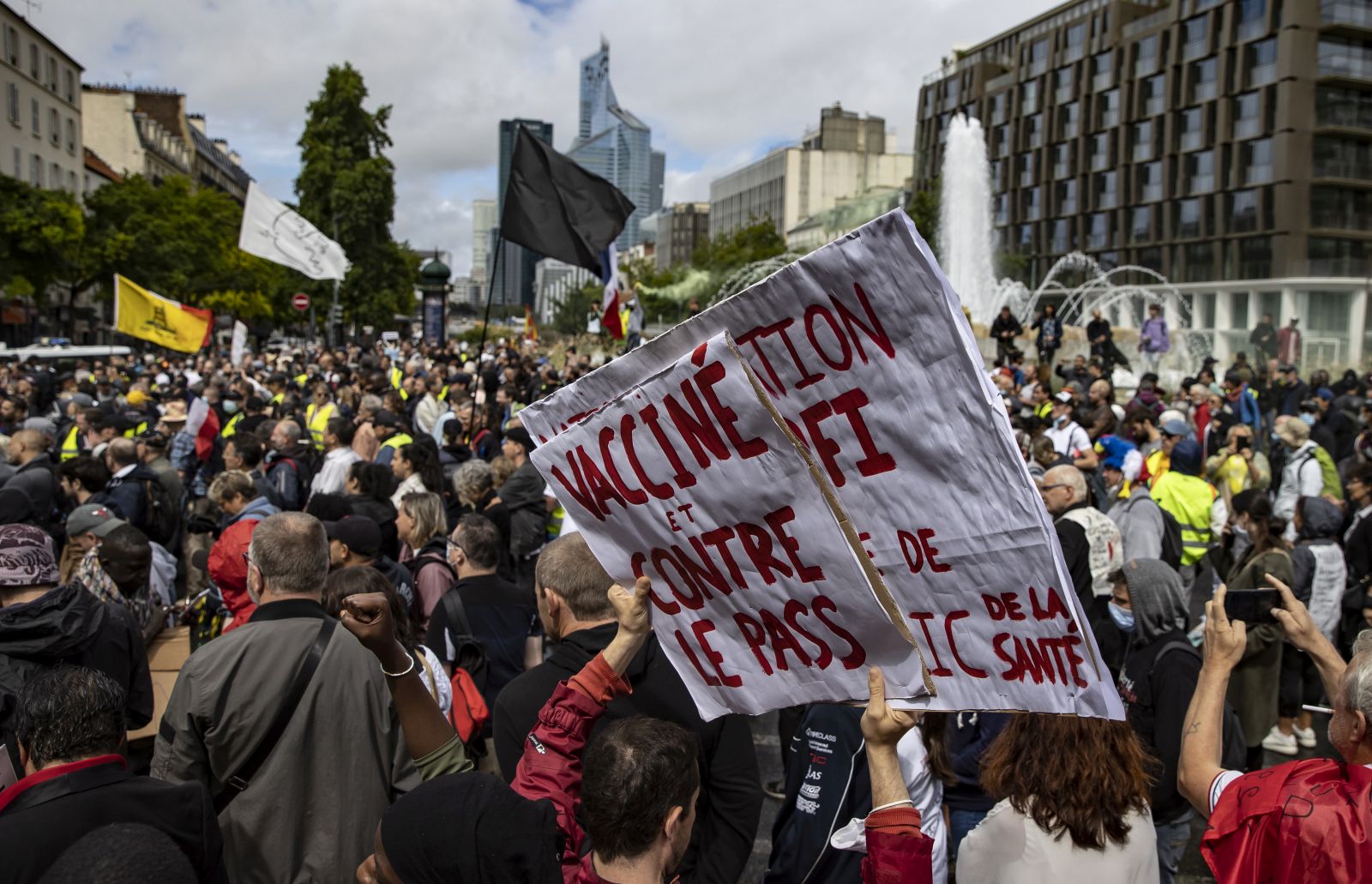 epa09404306 Protesters surrounded by anti-riot forces march during a demonstration against the COVID-19 health pass which grants vaccinated individuals greater ease of access to venues in France, in Paris, France, 07 August 2021. The national enforcement of the 'Health Pass' is expected to take effect on 09 August, after the French Constitutional Council has confirmed the government's law which extend the use of its Vaccinal Passeport (a QR code which proves the bearer has received full vaccination, or been tested negative for Covid in the last 72 hours) to cultural place, transport, and restaurants among other places.  EPA/IAN LANGSDON