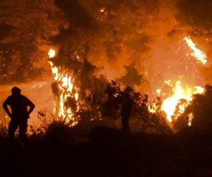 epa09409420 Residents and volunteers watch the development of the fire in a forest area near the village of Kamatriades in Evia, on the night of 10 August 2021 (issued on 11 August 2021). Fires that broke out in Attica and Evia island this week have burned more than a quarter of a million stremmas, the National Observatory of Athens' center Beyond said on 08 August. Some 76,150 stremmas (7,615 hectares) have been burnt so far in northern Attica. In Evia island the surface area of burnt land is measured at 197,940 stremmas (19,794 hectares). These figures concern only the fires in Attica and Evia, but dozens of large fires have affected several areas across the country.  EPA/SPIROS KOUROS