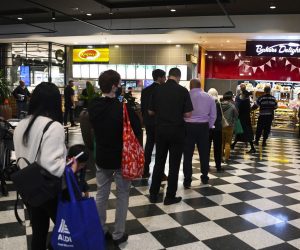 epa09410588 Customers stand in long lines at a check out counter at a bakery in the Woden area in Canberra, Australian Capital Territory, Australia, 12 August 2021. The ACT is going into a seven day lockdown after the discovery of the first local COVID-19 case in over a year.  EPA/LUKAS COCH AUSTRALIA AND NEW ZEALAND OUT
