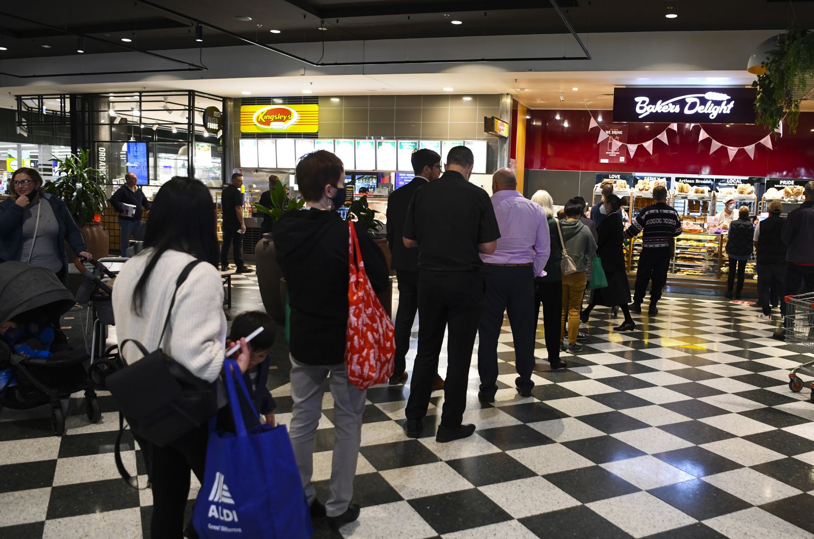epa09410588 Customers stand in long lines at a check out counter at a bakery in the Woden area in Canberra, Australian Capital Territory, Australia, 12 August 2021. The ACT is going into a seven day lockdown after the discovery of the first local COVID-19 case in over a year.  EPA/LUKAS COCH AUSTRALIA AND NEW ZEALAND OUT