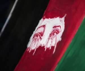 epa09418571 A poster displaying the eyes of a woman crying  on a Afghan flag is displayed during a vigil in support of Afghanistan in front of the West Los Angeles Federal Building, in Los Angeles, California, USA, 17 August 2021.  EPA/ETIENNE LAURENT