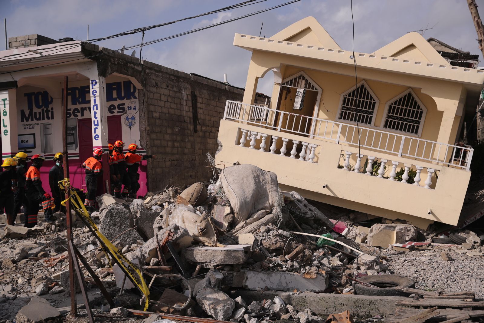 epa09423627 Mexican rescuers, from the Topos International Rescue Brigade, search for possible survivors of the 7.2 earthquake that occurred on 14 August, in Les Cayes, Haiti, 21 August 2021. The earthquake left some 2,200 dead and 12,000 wounded.  EPA/ORLANDO BARRIA