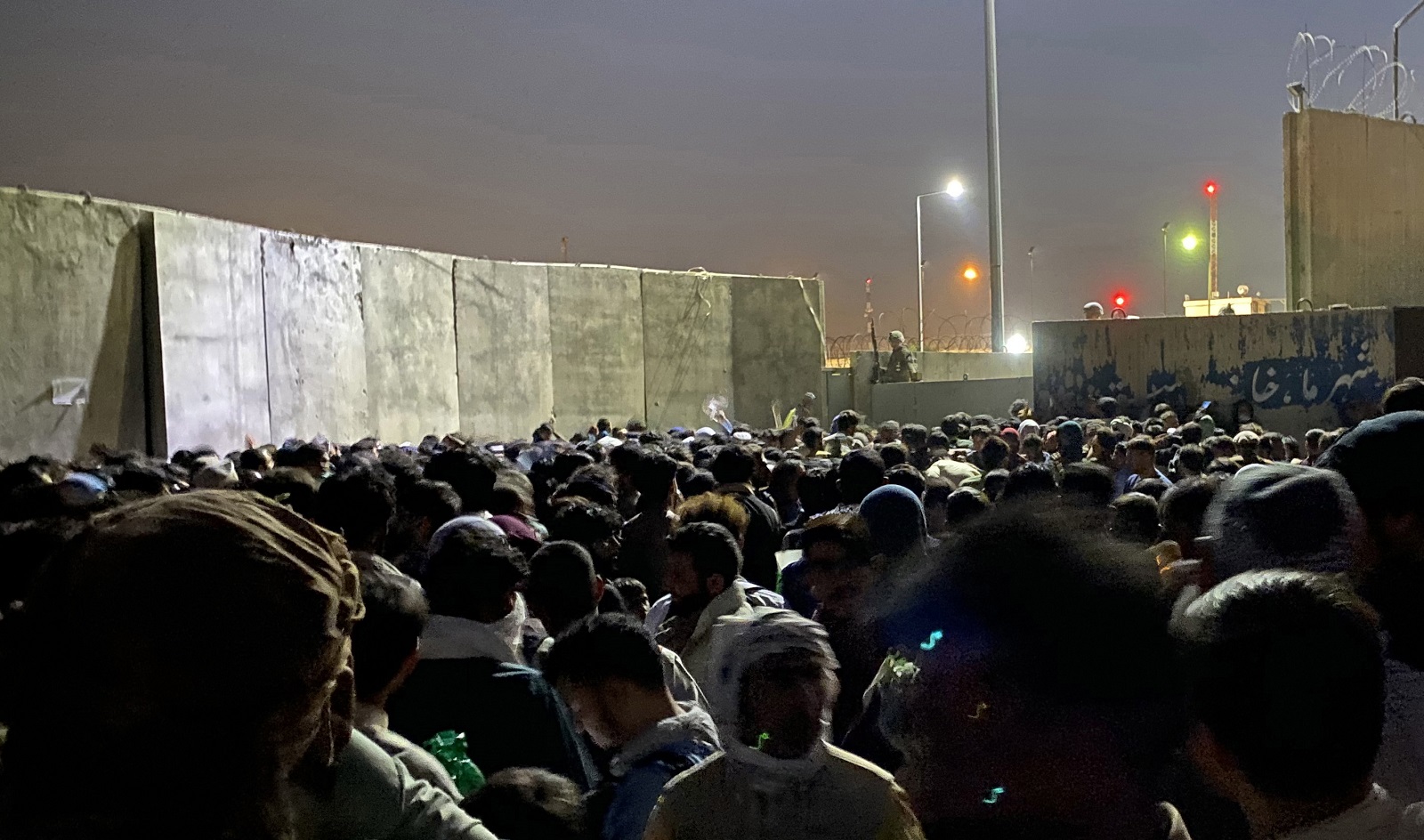 epa09426439 People struggle to get into the Hamid Karzai International Airport, to flee the country, in Kabul, Afghanistan, 23 August 2021. An Afghan policeman was killed on 23 August, in a gun battle between security forces and unknown attackers at the North Gate of the Kabul airport, the German military said, amid ongoing chaos at the airport as thousands try to flee Taliban rule.  EPA/STRINGER