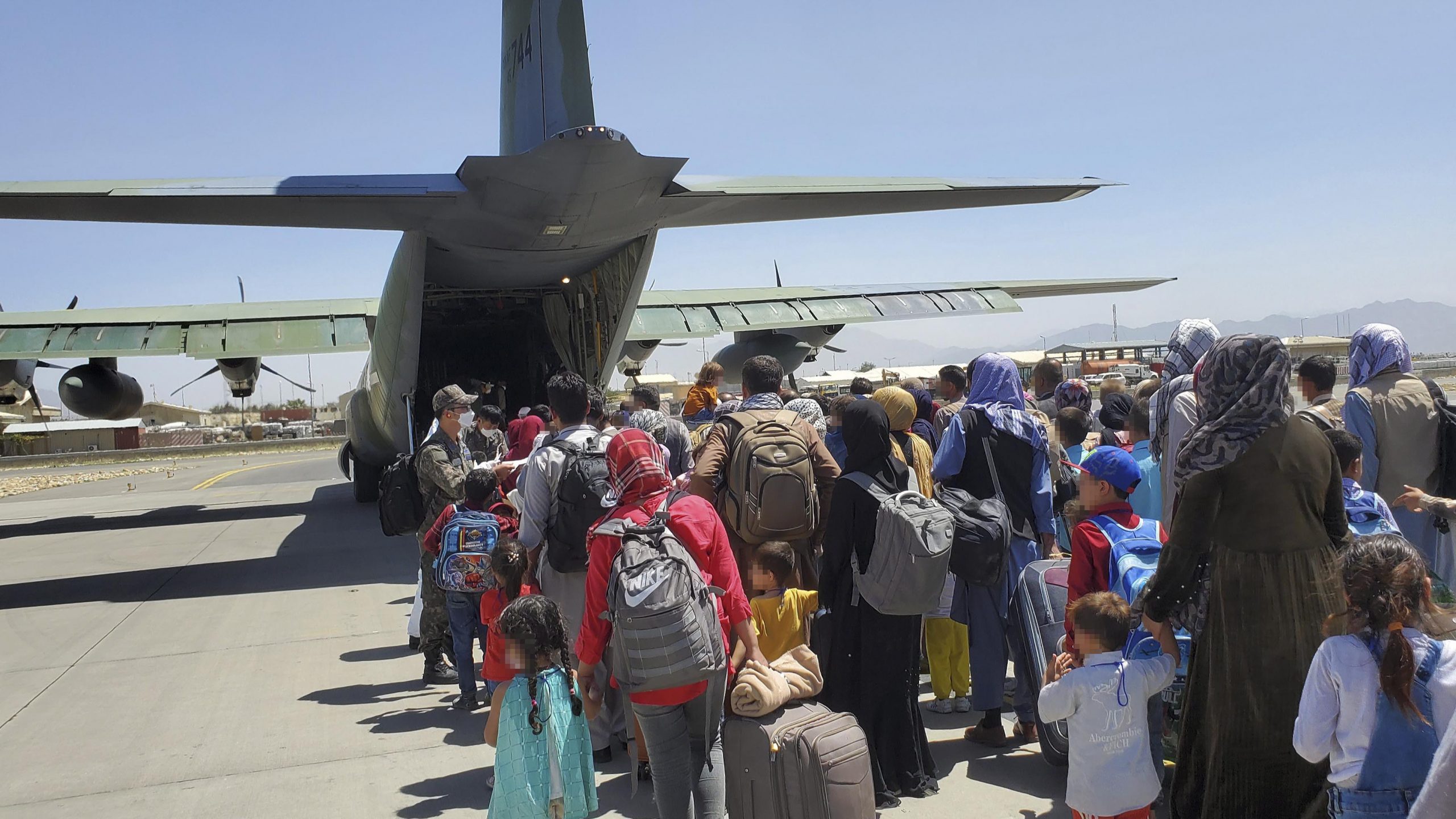 epa09429709 A handout photo made available by the Republic of Korea Air Force shows some 380 Afghans who have worked for South Koreans in their war-ravaged nation and their family members boarding a South Korea military plane at an airport in Kabul, Afghanistan, 25 August 2021, to head for South Korea.  EPA/REPUBLIC OF KOREA AIR FORCE / HANDOUT SOUTH KOREA OUT 
ATTENTION EDITORS: IMAGE PIXELATED AT SOURCE HANDOUT EDITORIAL USE ONLY/NO SALES