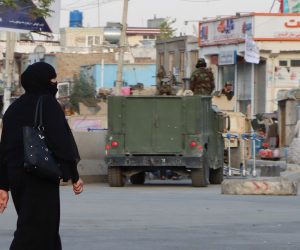epa09435091 A woman passes by the Taliban as they stand guard outside the Hamid Karzai International Airport in Kabul, Afghanistan, 29 August 2021. The process of withdrawing the 5,000 United States military personnel deployed to Kabul's airport for the evacuation of Americans and Afghan allies is under way in the face of 'very real' threats of additional attacks such as the one two days ago that left some 200 people dead, the Pentagon said 28 August. More than 117,000 people have departed from the Kabul airport since the 'massive military, diplomatic, security and humanitarian undertaking' began following the fall of the capital to the Taliban on 15 August.  EPA/STRINGER