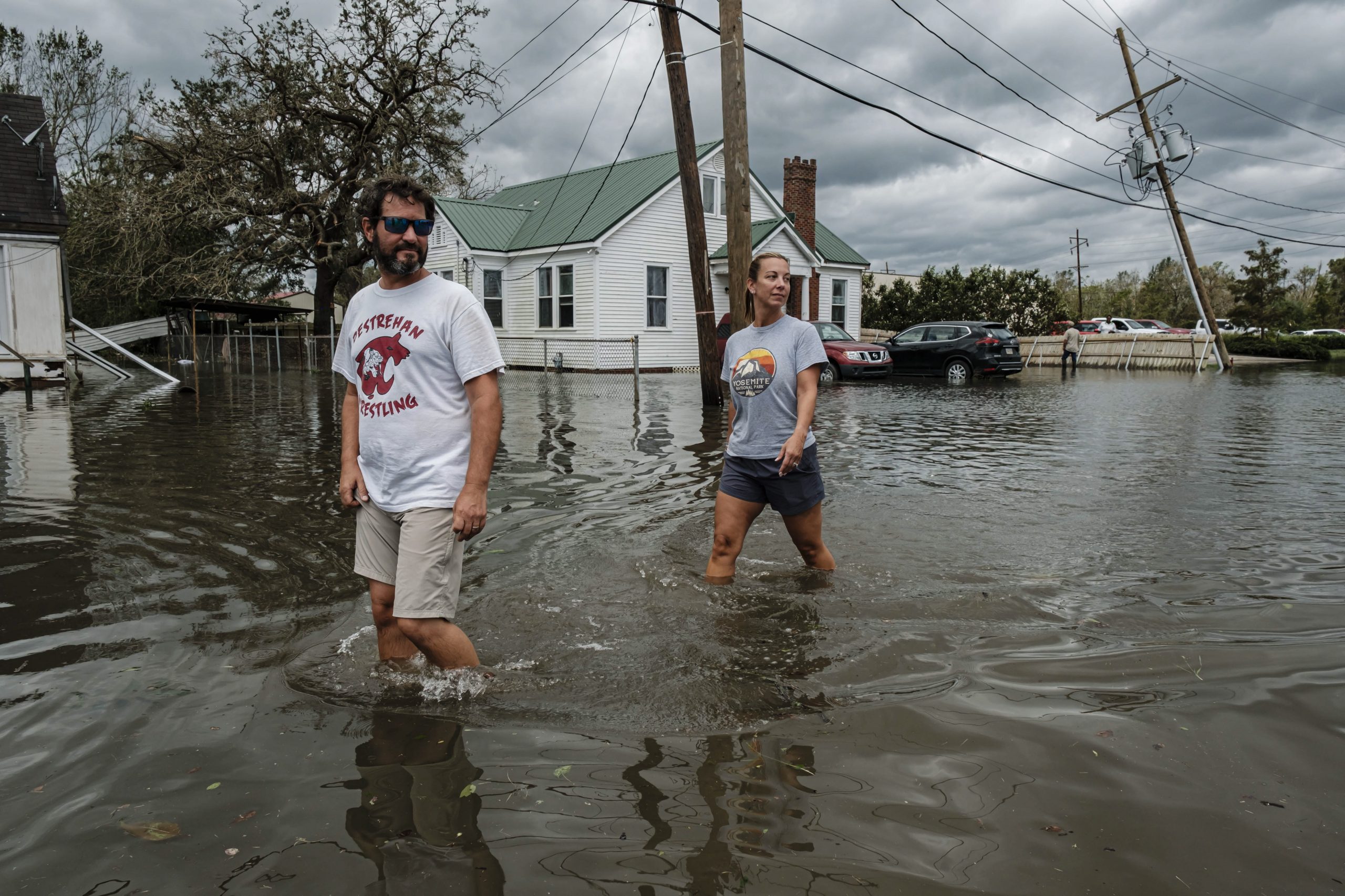 epa09437391 Two people walk through a flooded neighborhood from Hurricane Ida in Narco, Louisiana, USA, 30 August 2021. Hurricane Ida made landfall as a Category 4 storm bringing damaging winds and rain to southern Louisiana, knocking out power to more than one million people and flooding neighborhoods. At least one person was reported killed by the passing of the hurricane.  EPA/DAN ANDERSON