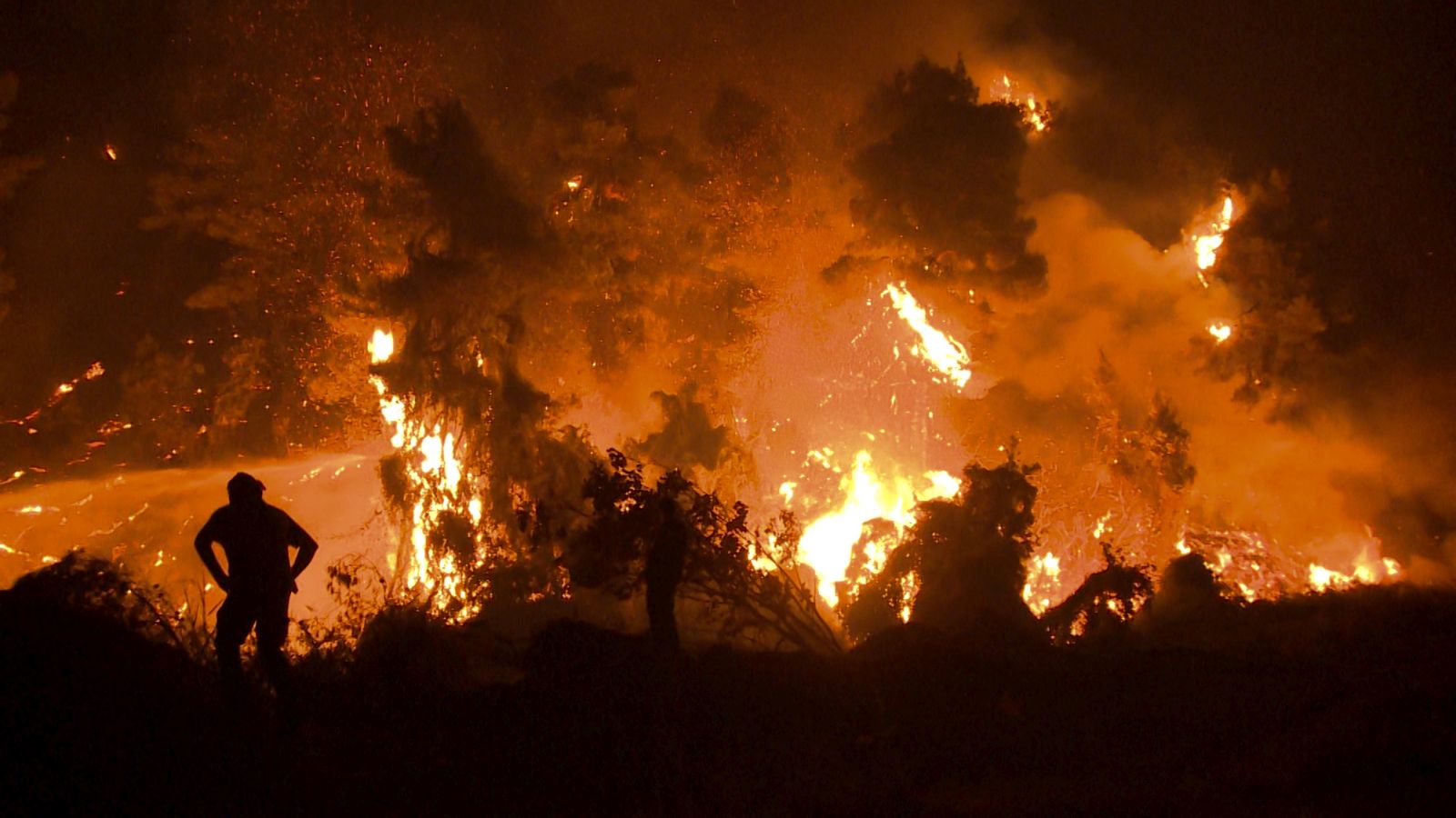 epa09409420 Residents and volunteers watch the development of the fire in a forest area near the village of Kamatriades in Evia, on the night of 10 August 2021 (issued on 11 August 2021). Fires that broke out in Attica and Evia island this week have burned more than a quarter of a million stremmas, the National Observatory of Athens' center Beyond said on 08 August. Some 76,150 stremmas (7,615 hectares) have been burnt so far in northern Attica. In Evia island the surface area of burnt land is measured at 197,940 stremmas (19,794 hectares). These figures concern only the fires in Attica and Evia, but dozens of large fires have affected several areas across the country.  EPA/SPIROS KOUROS
