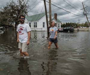 epa09437391 Two people walk through a flooded neighborhood from Hurricane Ida in Narco, Louisiana, USA, 30 August 2021. Hurricane Ida made landfall as a Category 4 storm bringing damaging winds and rain to southern Louisiana, knocking out power to more than one million people and flooding neighborhoods. At least one person was reported killed by the passing of the hurricane.  EPA/DAN ANDERSON