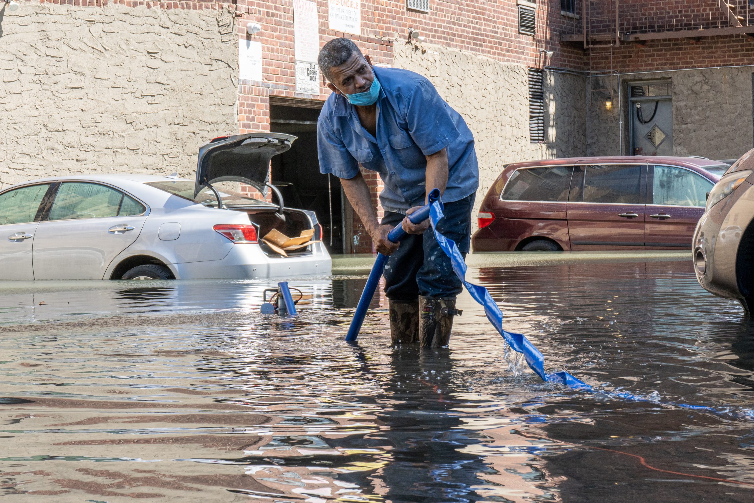 epa09444090 A man adjusts a water pump in a parking lot after the remnants of Hurricane Ida produced heavy rain and caused widespread flooding in New York City, New York, USA, 02 September 2021.  EPA/ANGEL COLMENARES