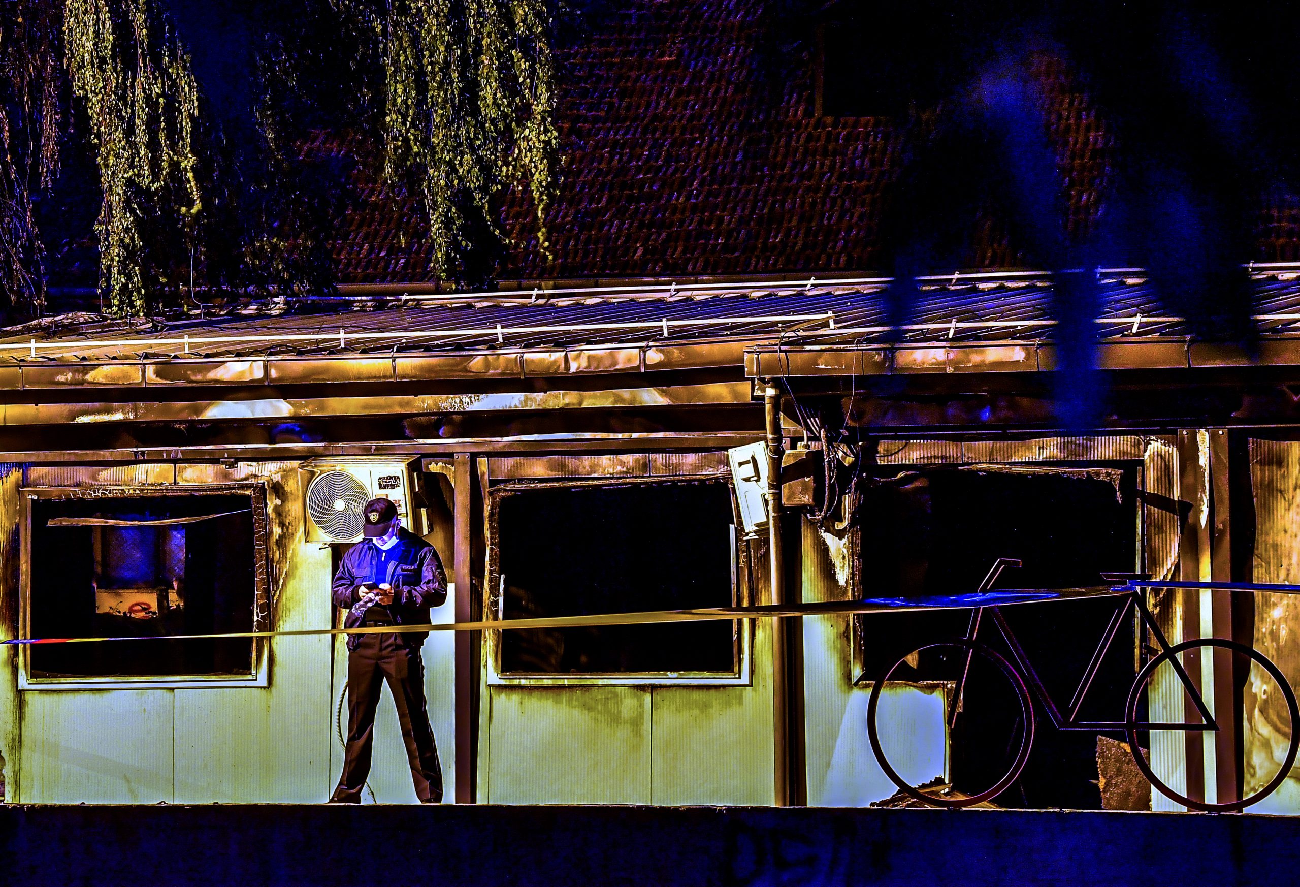 epa09456517 A police officer secures the site at a burned out makeshift hospital after a fire at a COVID-19 center in Tetovo, Republic of North Macedonia, 08 September 2021. According by Macedonian health minister Venko Filipce, at least 10 people died in a fire at a hospital treating coronavirus patients in Tetovo. 'At the moment, 10 people are confirmed to have died, but that number could rise,' Minister Filipce wrote, expressing his 'profound condolences' to the victims' families.  EPA/Georgi Licovski