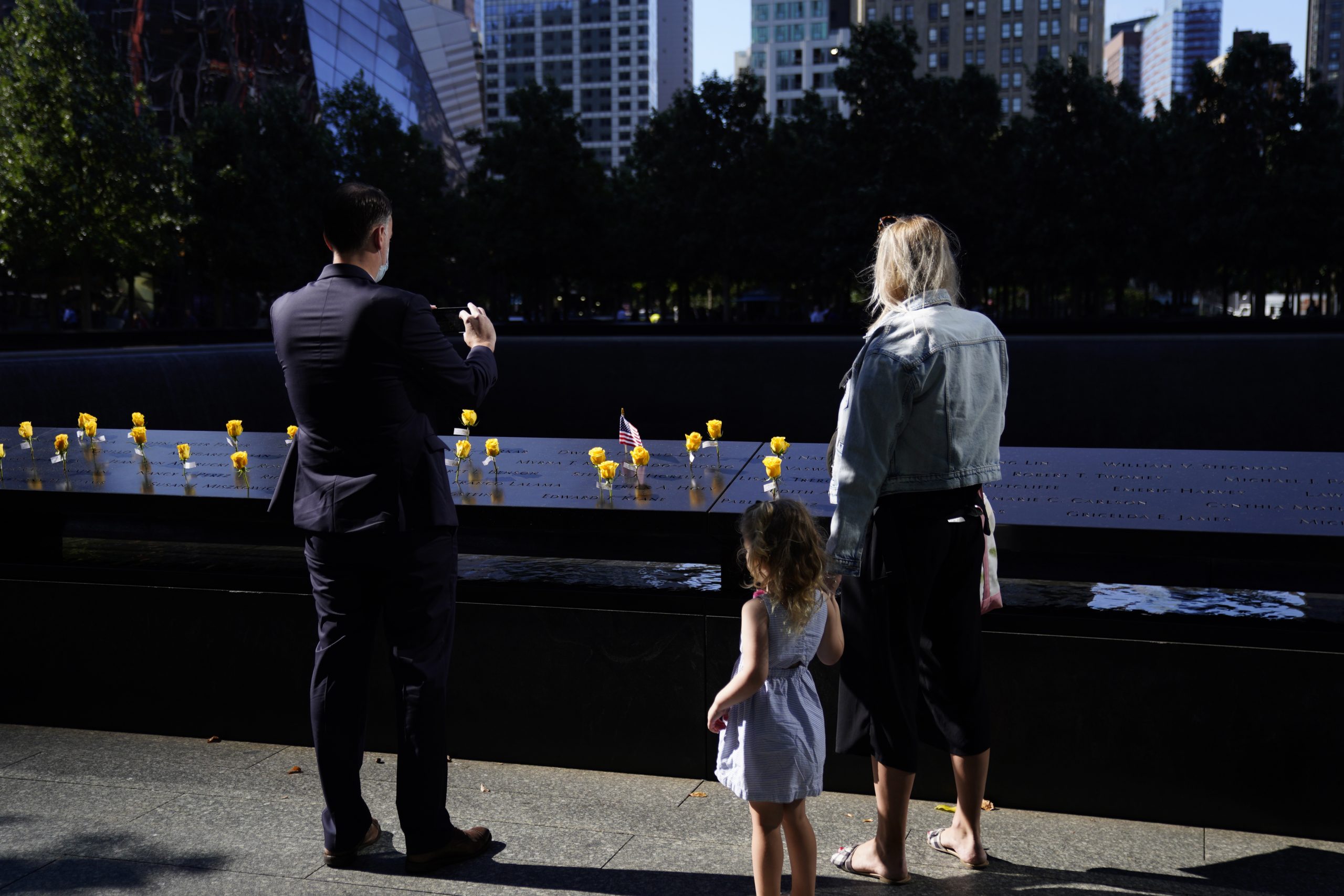 epa09459965 Members of the public pay their respects at the 9/11 Memorial in New York, New York, USA, 10 September 2021. The 20th anniversary of the worst terrorist attack on US soil will be observed on 11 September 2021.  EPA/WILL OLIVER