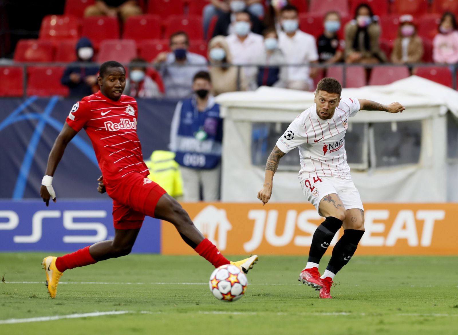 epa09468077 Sevilla FC's Alejandro Dario Gomez (R) in action against Salzburg's Mohamed Camara during the UEFA Champions League Group G soccer match between Sevilla FC and RB Salzburg at Sanchez Pizjuan stadium in Seville, southern Spain, 14 September 2021.  EPA/JOSE MANUEL VIDAL