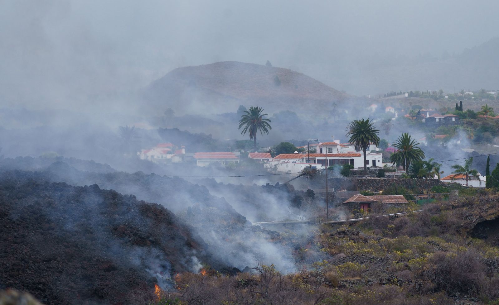 epa09479207 The lava flow from the Cumbre Vieja volcano moves towards the neighborhood of Todoque, in the municipality of Los Llanos de Aridane, after all locals were evacuated, in La Palma, Canary Islands, Spain, 21 September 2021.The Cumbre Vieja volcano began to erupt in Montana Rajada in the municipality of El Paso on 19 September.  EPA/Ramon de la Rocha