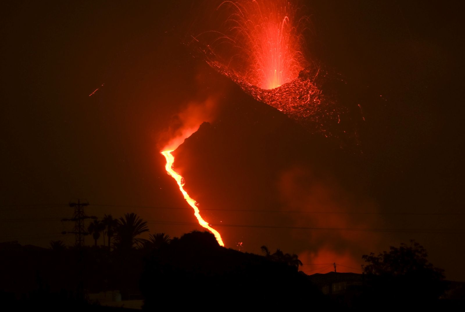 epa09490821 The Cumbre Vieja volcano erupts in La Palma island, Canary Islands, Spain, 27 September 2021. The Cumbre Vieja volcano began to erupt in the Montana Rajada mountains in the municipality of El Paso on 19 September. The area had registered hundreds of small earthquakes along the week as magma pressed the subsoil on its way out, urging the regional authorities to evacuate locals before the eruption took place.  EPA/ANGEL MEDINA