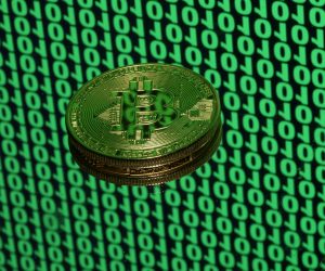 FILE PHOTO: Bitcoin token is seen placed on a monitor that displays binary digits in this illustration picture FILE PHOTO: A token of the virtual currency Bitcoin is seen placed on a monitor that displays binary digits in this illustration picture, December 8, 2017. REUTERS/Dado Ruvic/Illustration/File Photo Dado Ruvic