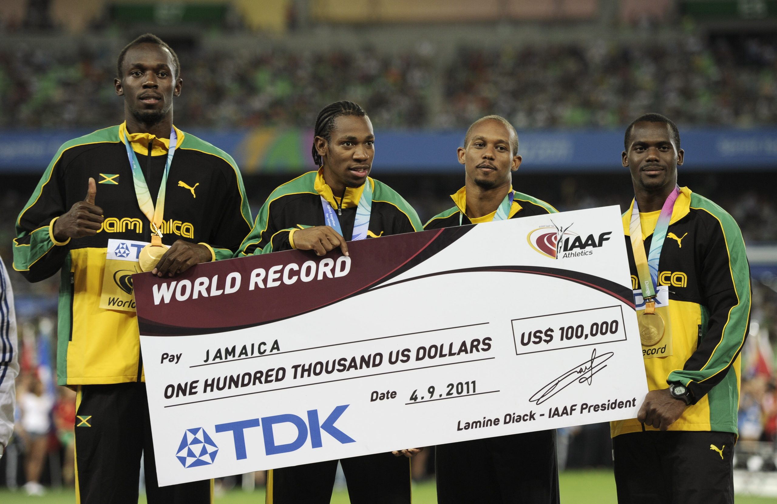 From left, Jamaica's Usain Bolt, Yohan Blake, Michael Frater and Nesta Carter pose on the podium after receiving their gold medals and a giant replica cheque for their new world record in the Men's 4x100 Relay at the World Athletics Championships in Daegu, South Korea, Sunday, Sept. 4, 2011. (AP Photo/Martin Meissner) (AP Photo/Martin Meissner)