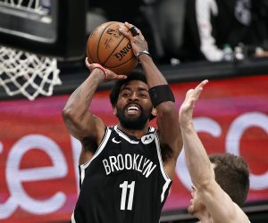 FILE - Brooklyn Nets guard Kyrie Irving (11) shoots against the Milwaukee Bucks during the second half of Game 1 of an NBA basketball second-round playoff series in New York, in this Saturday, June 5, 2021, file photo. Players like Kyrie Irving, who has refused to say if he will be vaccinated against COVID-19, will be subject to testing on all NBA practice, travel and game days this season. Fully vaccinated players will not. (AP Photo/Adam Hunger, File)